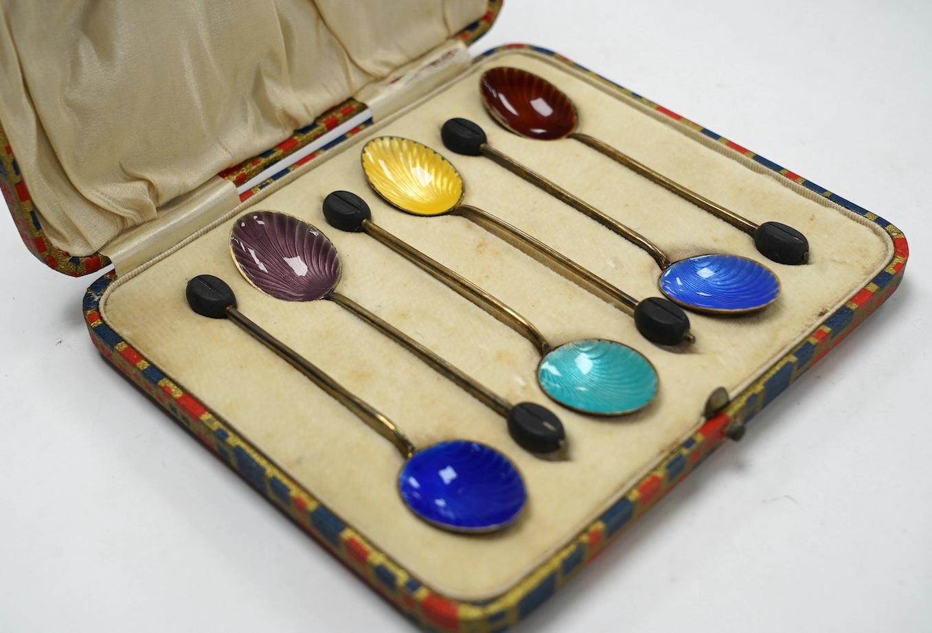 A cased set of six George V silver and polychrome enamelled coffee spoons, by Henry Clifford Davis, Birmingham, 1919. Condition - fair